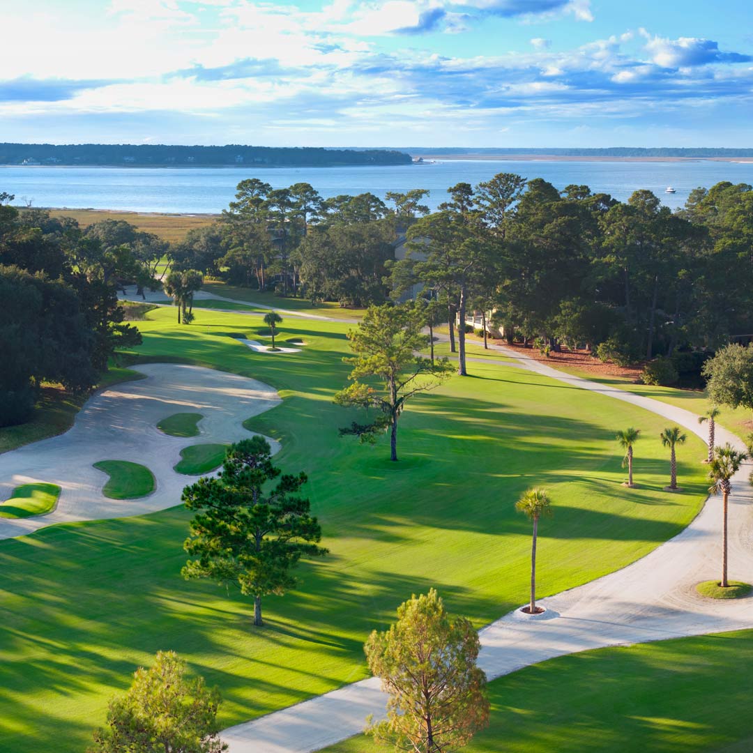 Aerial view of the 16th hole, featuring a winding fairway, sculpted bunkers, and coastal marshland along Hilton Head Island.