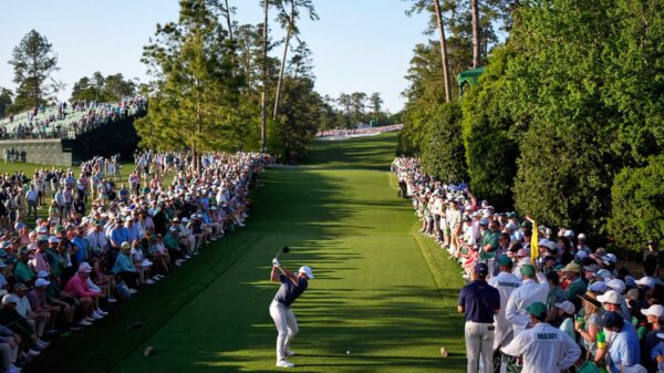 Rory McIlroy tees off at Augusta National during the 2025 Masters with a gallery lining the fairway
