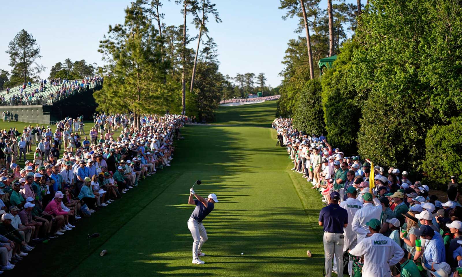 Rory McIlroy tees off at Augusta National during the 2025 Masters with a gallery lining the fairway