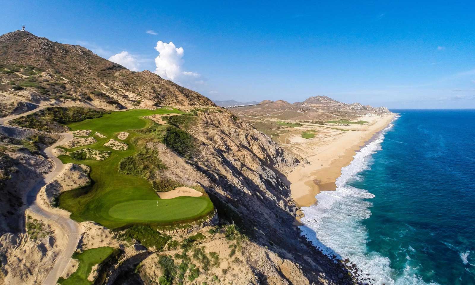 Aerial view of Quivira Golf Club in Los Cabos, showing a dramatic cliffside golf hole overlooking the Pacific Ocean and Baja coastline.