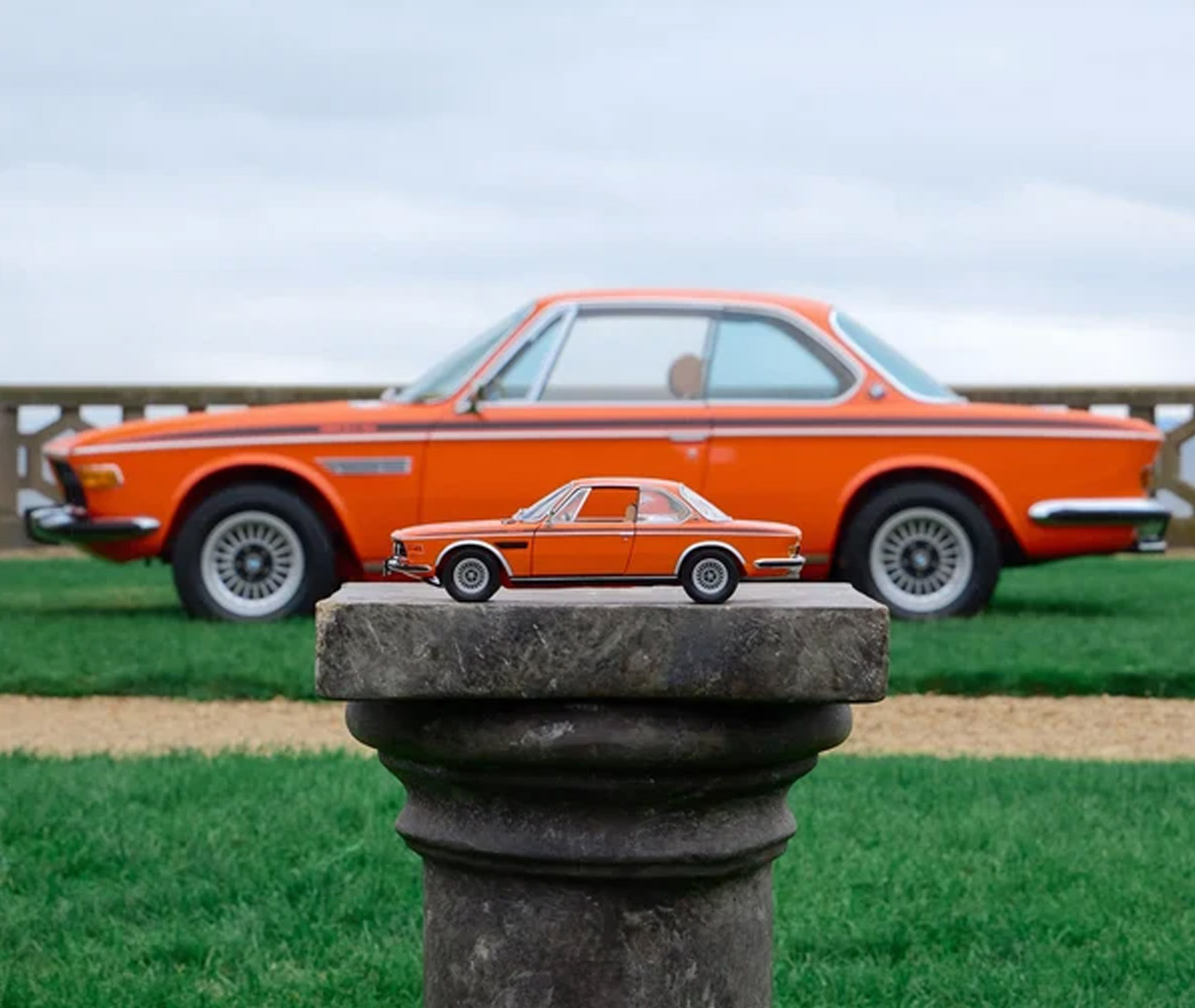The Kith and BMW restored 1972 3.0 CSi and miniature replica in Inka Orange.